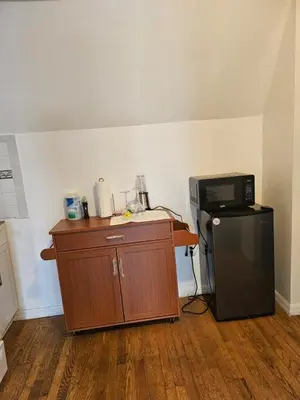 a kitchen with a microwave and a small refrigerator at UD guest house in East Orange
