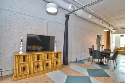 a living room with a television on a wooden entertainment center at Wonder Honesdale -Loft A2 in Honesdale