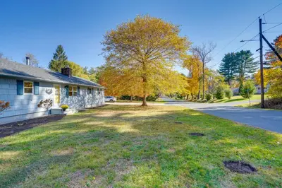 a house with a tree in the middle of a yard at 1 Mi to Dtwn Cottage with Large Yard in Stockbridge in Stockbridge