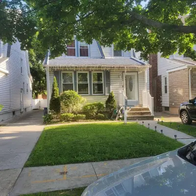 a house with a car parked in front of it at Adorable 2 Bedrooms in Bellerose NY in Bellerose