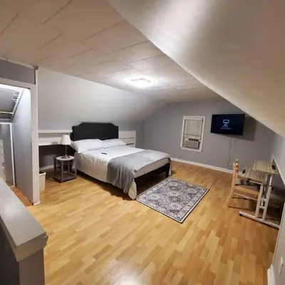 a bedroom with a large bed in a attic at Adorable 2 Bedrooms in Bellerose NY in Bellerose