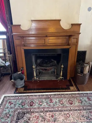 a fireplace in a living room with a rug at Haslett House - A Gilded Age Estate in Fort Plain