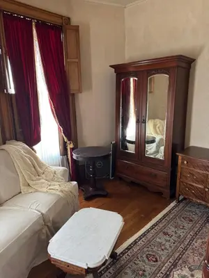 a living room with a couch and a dresser at Haslett House - A Gilded Age Estate in Fort Plain