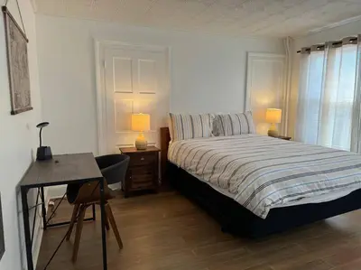 a bedroom with a bed and a desk and two lamps at Private Apartment with NYC VIEWS right outside NYC in Jersey City