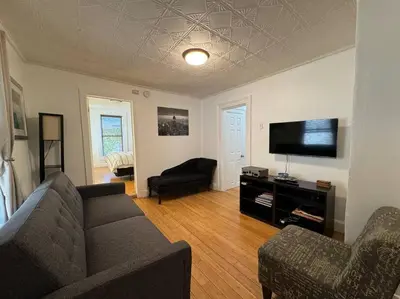 a living room with a couch and a flat screen tv at Private Apartment with NYC VIEWS right outside NYC in Jersey City