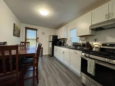 a kitchen with a table and a stove top oven at Private Apartment with NYC VIEWS right outside NYC in Jersey City