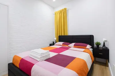 a bedroom with a bed with a colorful blanket at 2 Bedroom Modern Unit in Central Manhattan in New York