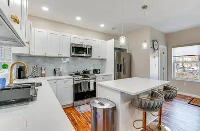 a kitchen with white cabinets and a white counter top at Townhouse - Urban Living with Rooftop Deck! in Newark