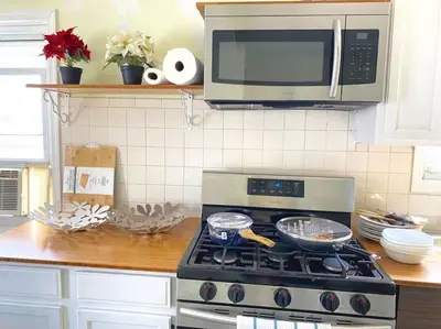 a kitchen with a stove and a microwave at 3-bedrooms Journal Square near NYC in Jersey City