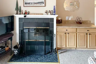 a living room with a fireplace and a counter at Snow Mountain Village 13F in Dover