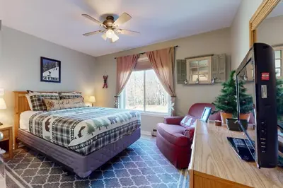 a bedroom with a bed and a tv and a couch at Snow Mountain Village 13F in Dover