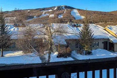 a house covered in snow with a mountain in the background at Snow Mountain Village 13F in Dover