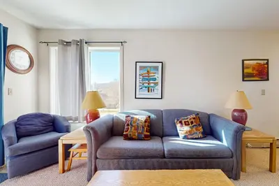 a living room with a blue couch and a chair at Snow Mountain Village 13A in Dover