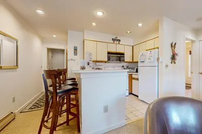 a kitchen with white appliances and wooden cabinets at Snow Mountain Village 13A in Dover