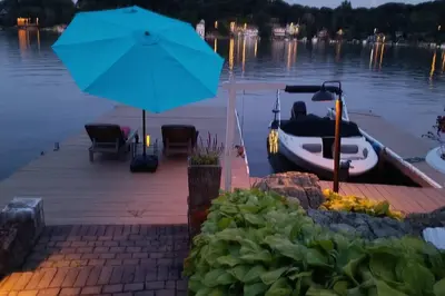 a boat on a dock with a blue umbrella at Falcon's Nest, Lakefront at Byram Cove, Hopatcong in Andover