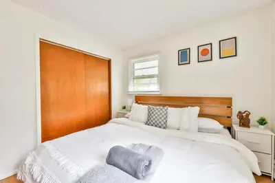 a bedroom with a large white bed with a wooden headboard at Hunter Hideaway with Hot Tub in Lanesville