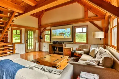 a living room with a couch and a tv at Private Woodland Retreat with Cedar Hot Tub & Mt View in Gilboa