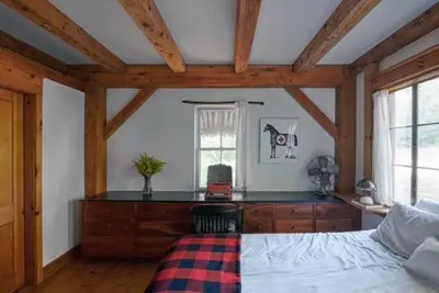 a bedroom with a bed in a room with wooden ceilings at Private Woodland Retreat with Cedar Hot Tub & Mt View in Gilboa