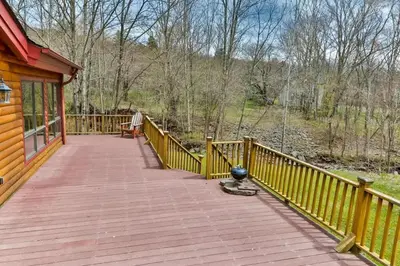 a wooden porch of a house with a wooden fence at 4 Bedroom Log Cabin with Stream and Great Location in Lanesville