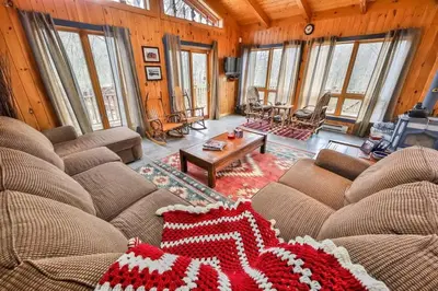 a living room with two couches and a coffee table at 4 Bedroom Log Cabin with Stream and Great Location in Lanesville