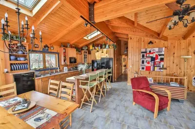 a kitchen and dining room with a table and chairs at 4 Bedroom Log Cabin with Stream and Great Location in Lanesville