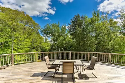 a patio with a table and chairs on a deck at Country Escape Overlooking Hunter & Windham Mts in Jewett
