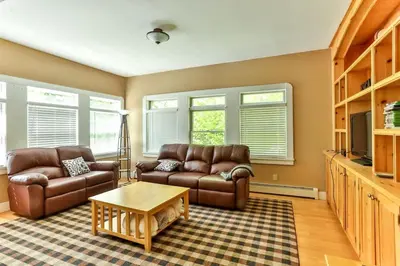 a living room with two leather couches and a coffee table at Country Escape Overlooking Hunter & Windham Mts in Jewett