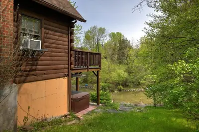 a cabin with a balcony on the side of it at Cozy Athens Cabin on the Lake with Hot Tub & Backyard in Athens