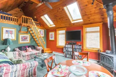 a living room with a couch and a wooden ceiling at Cozy Rustic Bliss Seconds from Windham Mt Resort in Windham