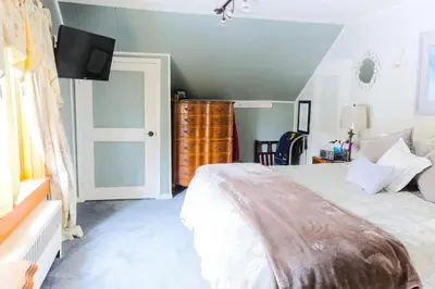 a bedroom with a bed and a tv on the wall at Cozy Rustic Bliss Seconds from Windham Mt Resort in Windham