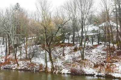 a snow covered field with trees and a river at Cozy Rustic Bliss Seconds from Windham Mt Resort in Windham