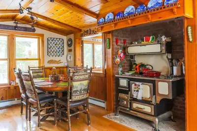 a dining room with a table and a stove at Cozy Rustic Bliss Seconds from Windham Mt Resort in Windham
