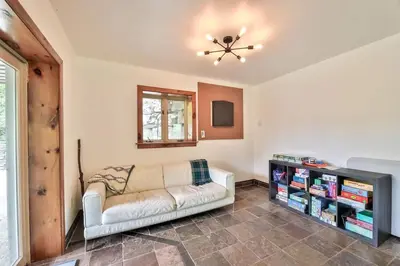 a living room with a couch and a book shelf at Dog-Friendly Mountain Hideaway in Jewett