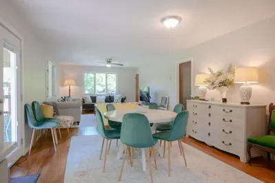 a living room with a table and green chairs at High Falls Hideout in Catskill