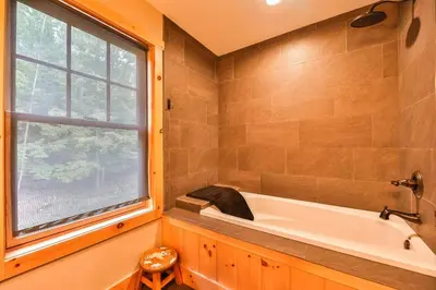 a bathroom with a tub and a window at Luxurious Home & Amazing Views in Windham