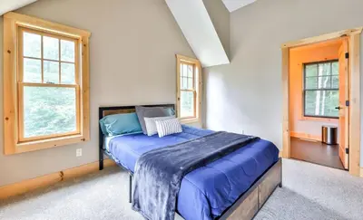 a bedroom with a bed and two windows at Luxurious Home & Amazing Views in Windham