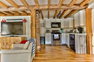 a living room with a couch and a kitchen at Majestic Mountain Retreat with Fire Pit Facing Mtn in Hunter