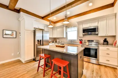 a kitchen with white cabinets and red stools at Mountain Cabin with Scenic Views and Hot Tub in Windham