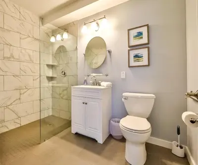 a bathroom with a toilet and a glass shower at Mountain Cabin with Scenic Views and Hot Tub in Windham