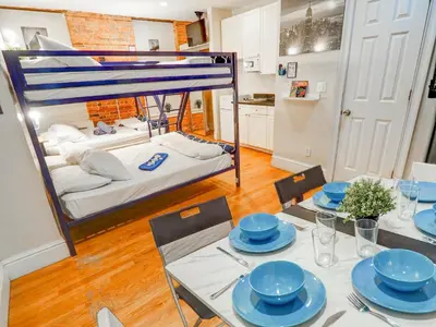 a dining room with a table and a bed at Metropolitan Studio Apartments Manhattan in New York