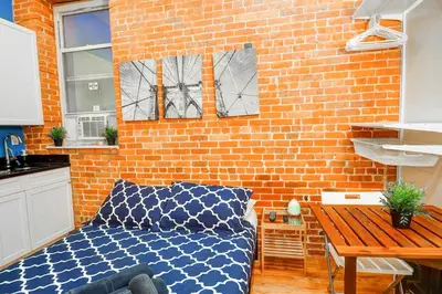 a room with a bed and a brick wall at Metropolitan Studio Apartments Manhattan in New York