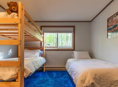 a bedroom with two bunk beds and a window at Retro Retreat Charming Home with Hot Tub & Fire Pit in Hensonville