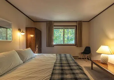 a bedroom with a bed and a desk and a window at Retro Retreat Charming Home with Hot Tub & Fire Pit in Hensonville
