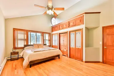 a bedroom with a bed and a ceiling fan at Stream-Side Atrium Home with Side Rooms & Pool Table in Hunter
