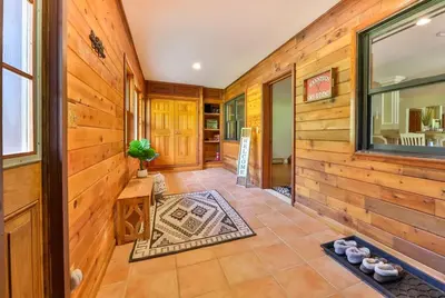 a hallway of a house with wooden walls at Stream-Side Atrium Home with Side Rooms & Pool Table in Hunter