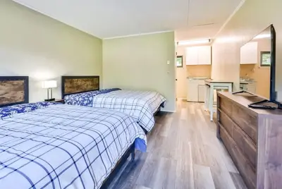 a bedroom with two beds and a kitchen with a sink at Stream-Side Atrium Home with Side Rooms & Pool Table in Hunter