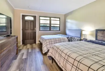 a bedroom with two beds and a flat screen tv at Stream-Side Atrium Home with Side Rooms & Pool Table in Hunter