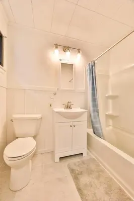 a white bathroom with a toilet and a sink at Stream-Side Atrium Home with Side Rooms & Pool Table in Hunter