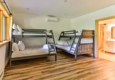 a room with three bunk beds and a wooden floor at Stunning Home with Hot Tub Fire Pit & Amazing Views in Hunter