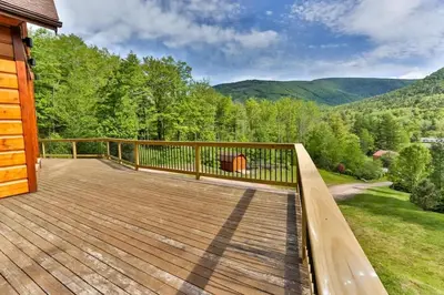 a wooden deck with a view of the mountains at Stunning Home with Hot Tub Fire Pit & Amazing Views in Hunter